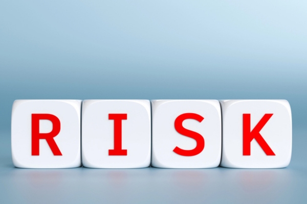 RISK spelled using white plastic letter cubes
