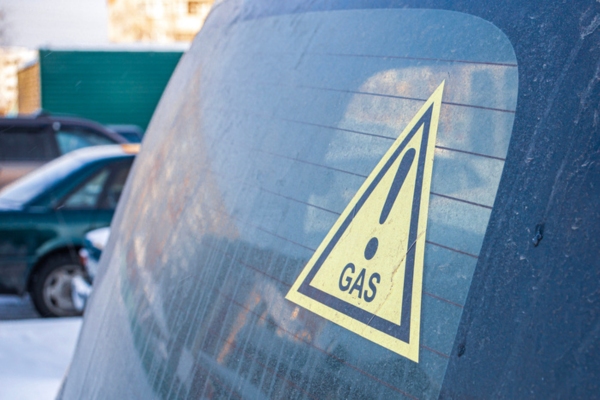 Sticker on a vehicle glass warning that the car is powered by propane