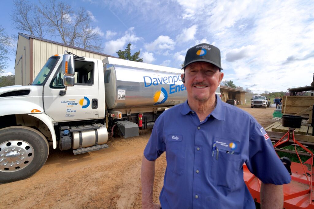 Smiling Davenport Energy driver standing in front of a heating oil delivery truck