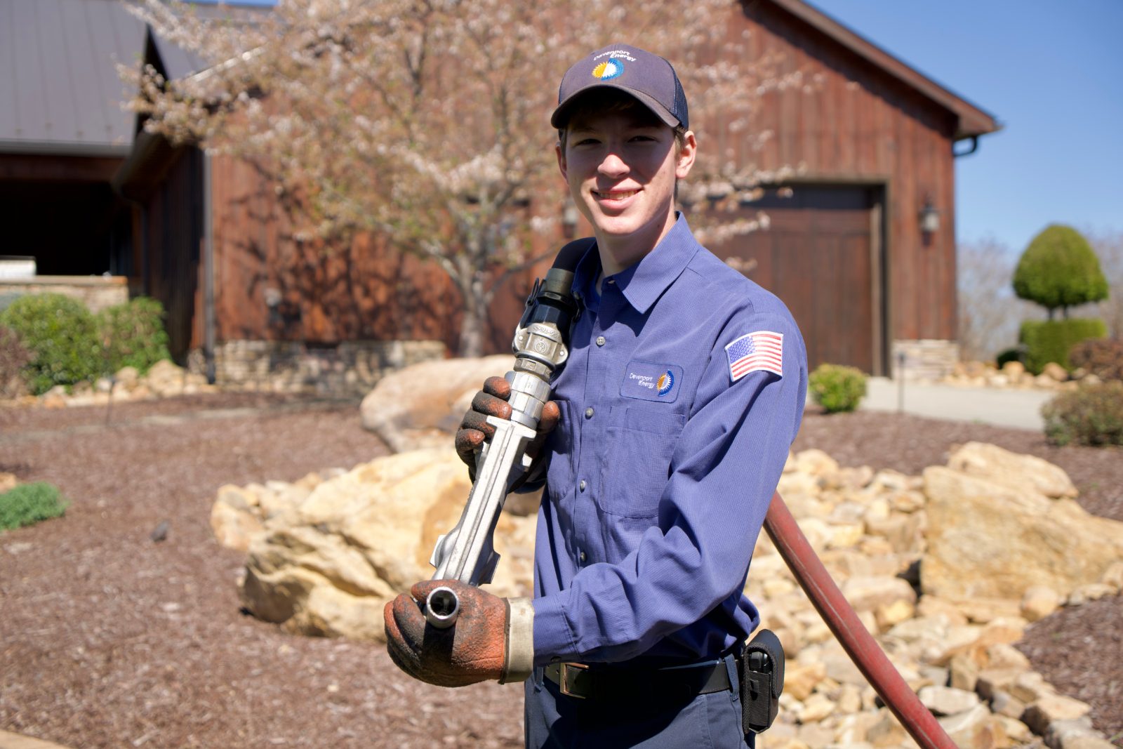Davenport Energy driver holding a fuel delivery nozzle during a home heating oil delivery