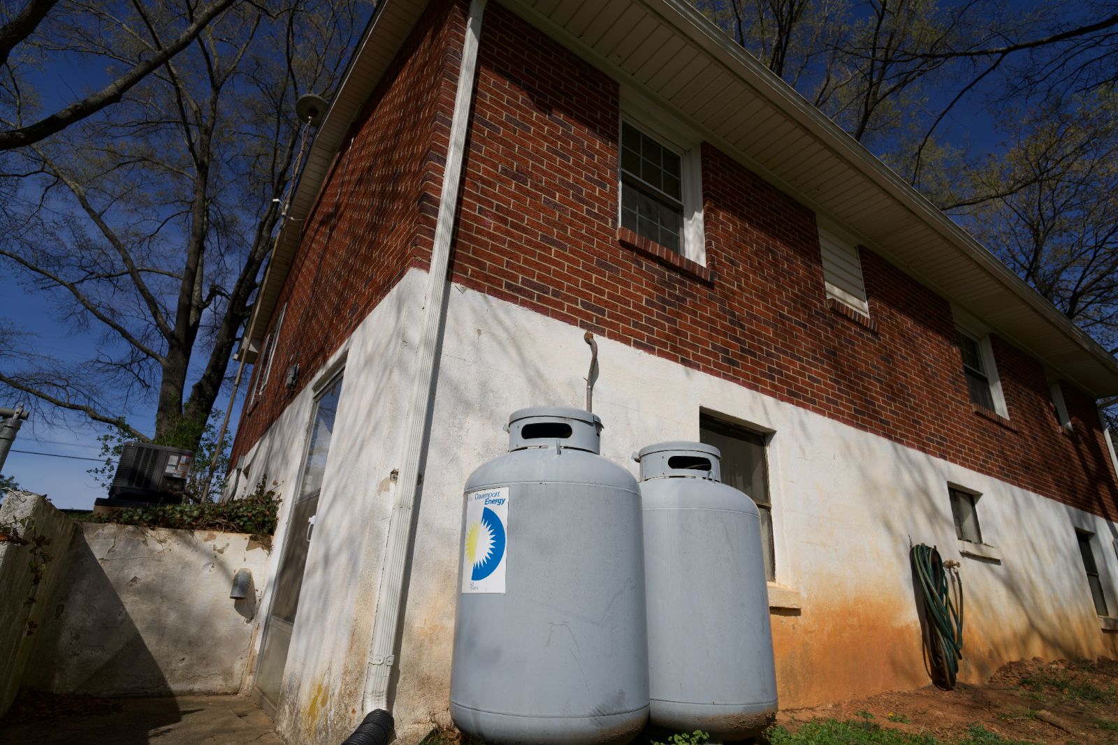 Two residential propane tanks with Davenport Energy branding beside a brick home